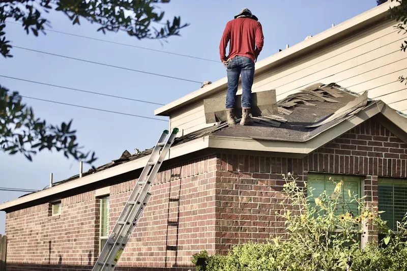 Professional roofer working on a residential roof in Camp Virginia